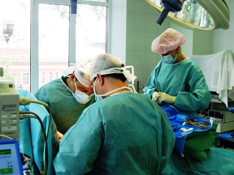 Врачи склонились над операционным столом в процессе операции